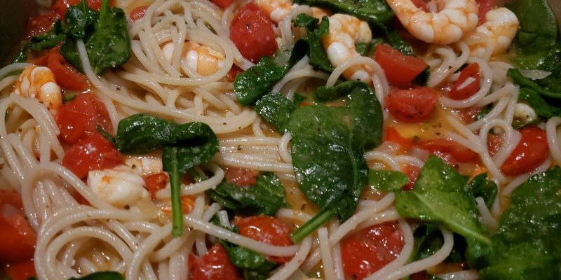 gluten free dairy free shrimp, spinach, and tomatoes over pasta